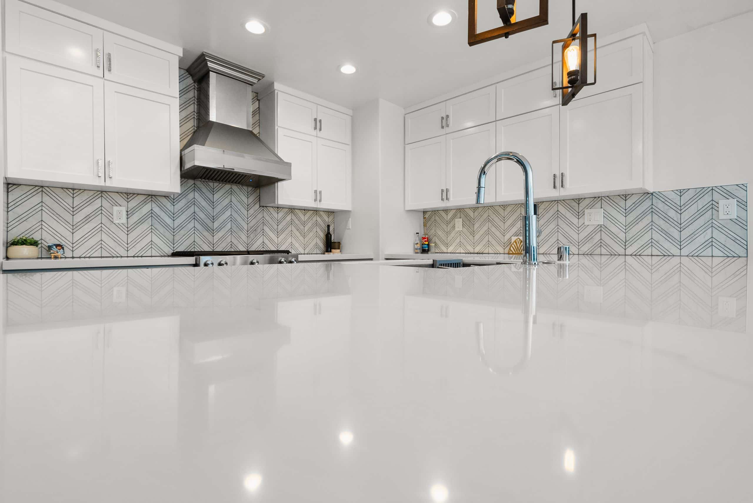 Range hood over the chevron marble backsplash