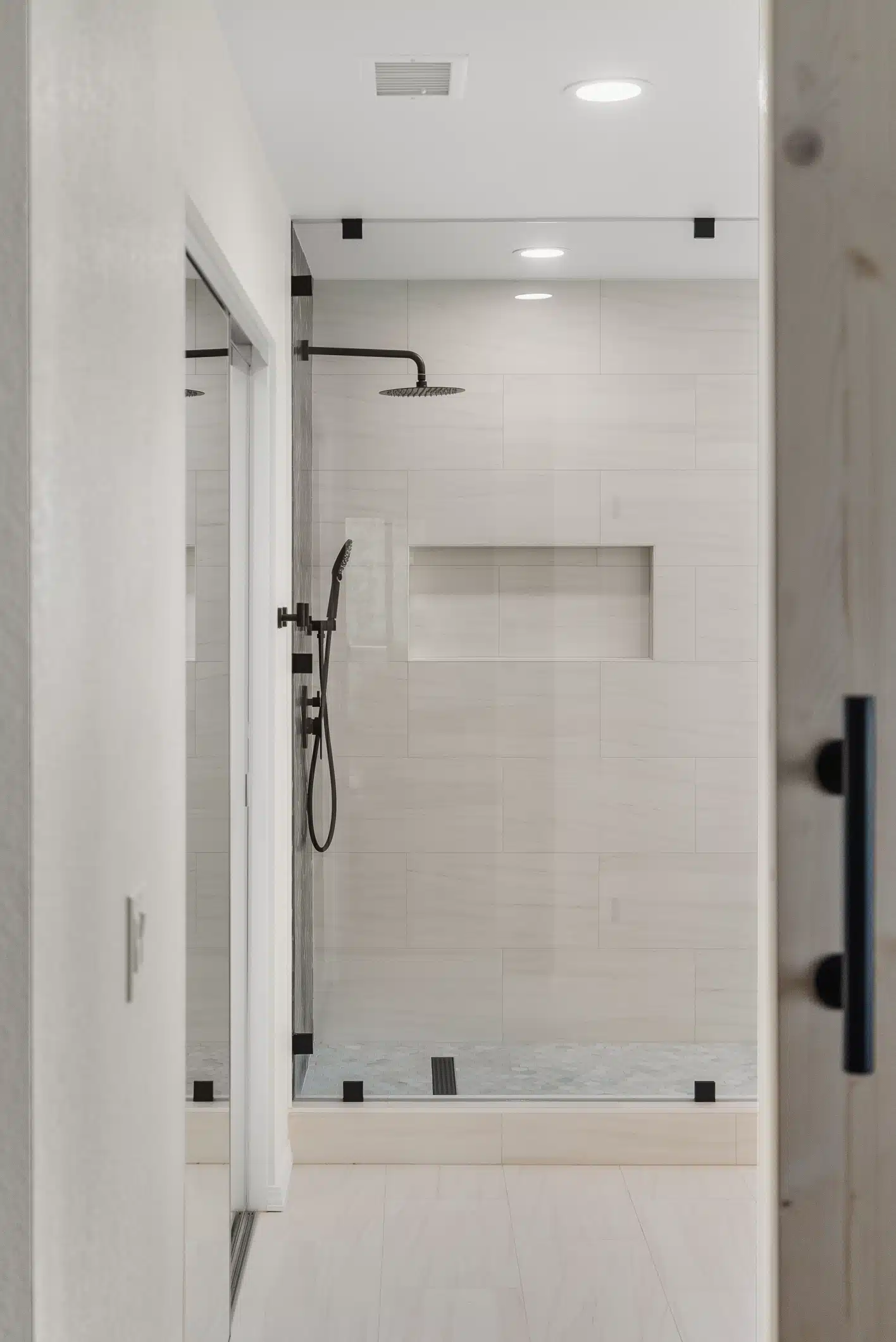 Moraga primary shower — matte-black fixtures and large-format marble-look tile