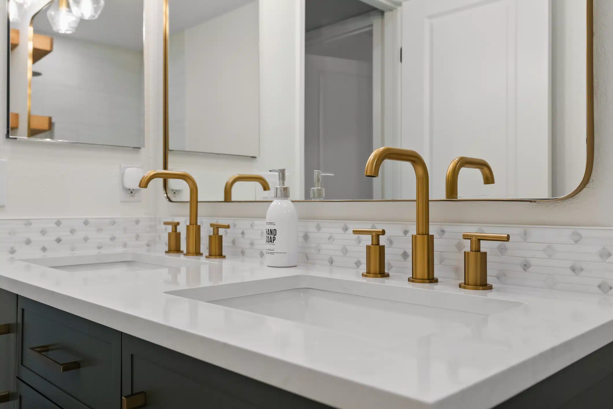 Moraga guest bath — double sinks with brushed-brass faucets and marble counter
