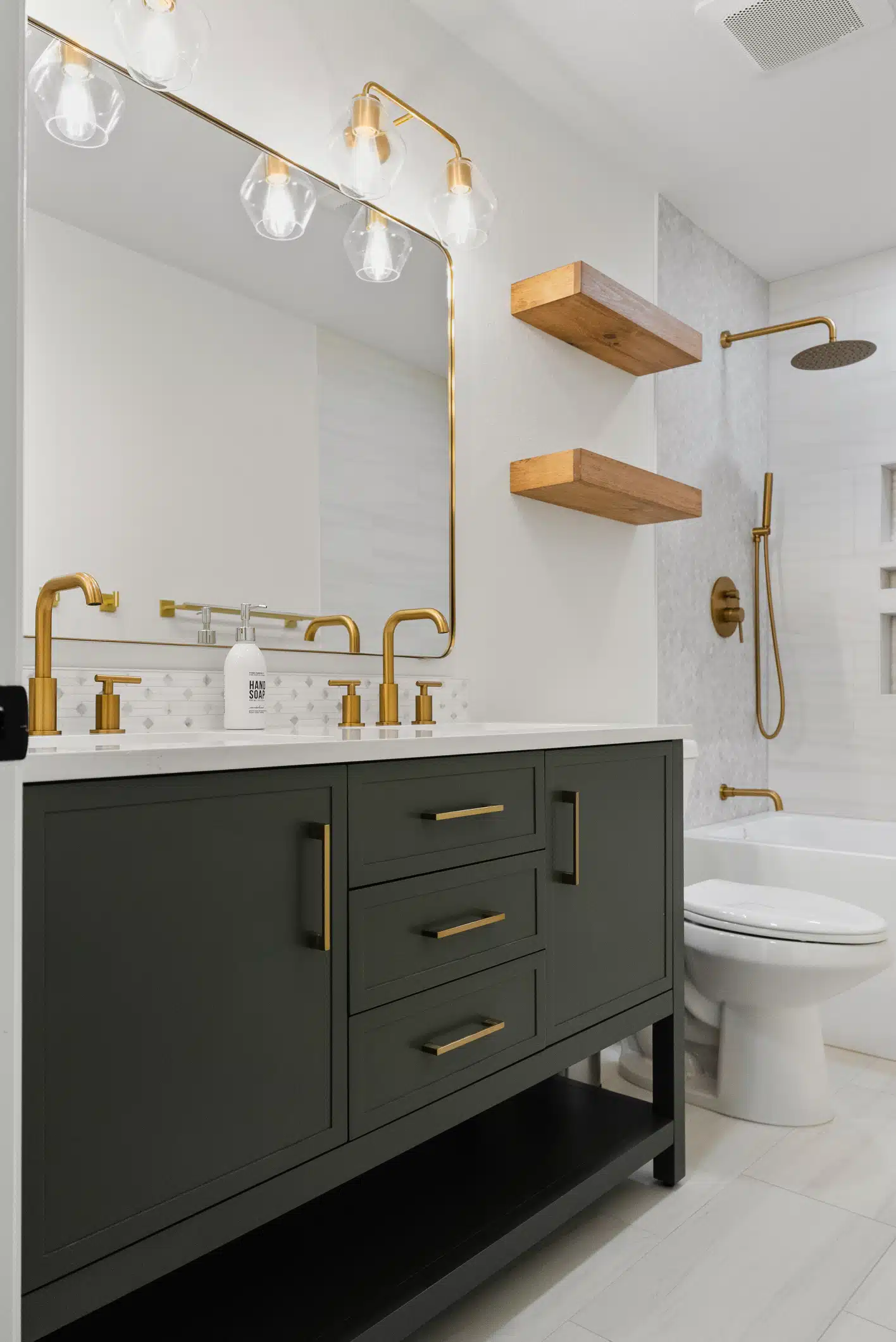 Moraga guest bathroom — sage-green vanity, floating wood shelves and brass fittings